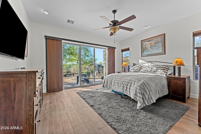 bedroom with light wood-type flooring, multiple windows, and ceiling fan