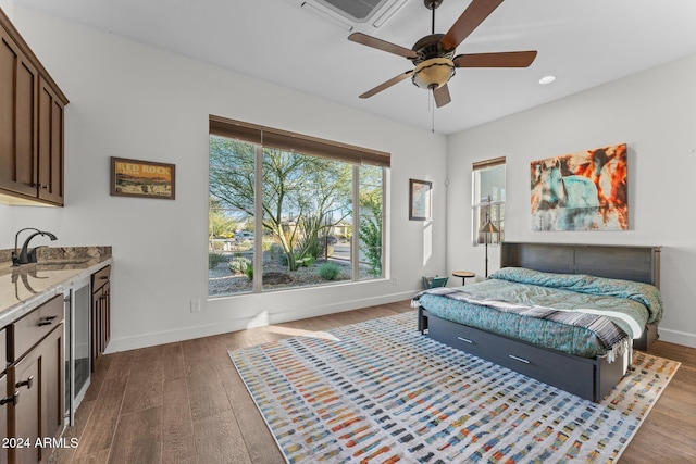 bedroom featuring hardwood / wood-style floors, ceiling fan, beverage cooler, and sink