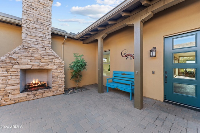 property entrance with a patio area and an outdoor stone fireplace