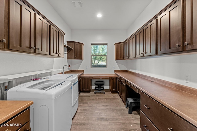 washroom featuring cabinets, light wood-type flooring, sink, and washing machine and dryer