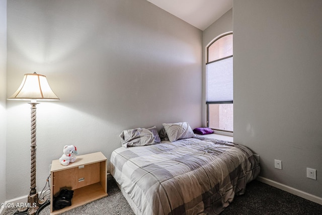 bedroom featuring vaulted ceiling and dark carpet