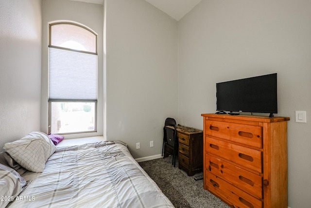 bedroom with vaulted ceiling and dark carpet