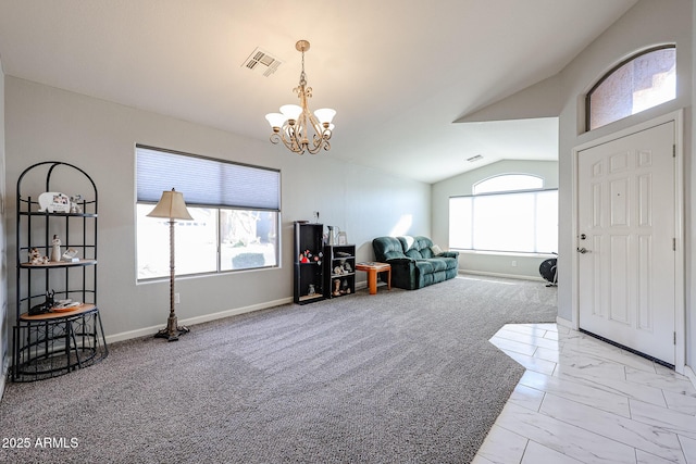 entryway featuring lofted ceiling, a wealth of natural light, and an inviting chandelier