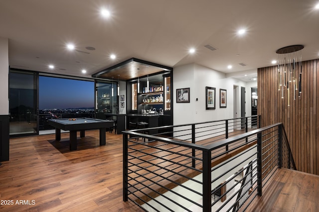 recreation room with wood-type flooring, billiards, and bar area