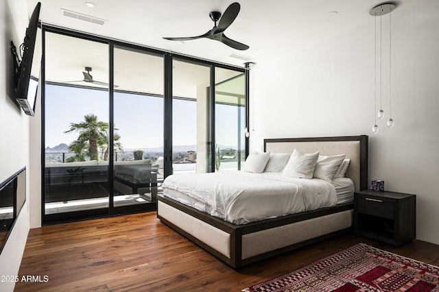 bedroom featuring access to exterior, a wall of windows, and dark hardwood / wood-style floors