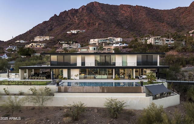 back of property featuring a mountain view and a patio area