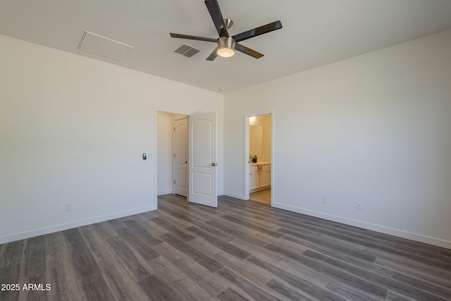 5096 S 245th Dr, Buckeye, AZ 85326 - unfurnished bedroom with dark wood-style floors, baseboards, connected bathroom, and ceiling fan