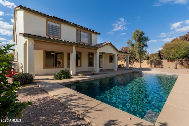 back of property featuring a fenced in pool, ceiling fan, and a patio area