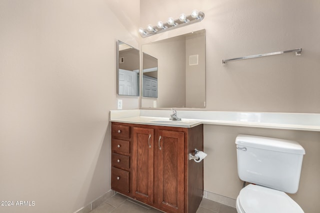 bathroom featuring toilet, vanity, and tile patterned flooring