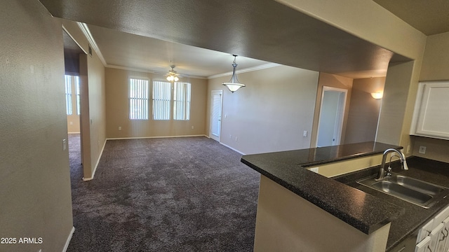 kitchen with ceiling fan, sink, dark carpet, and white cabinets