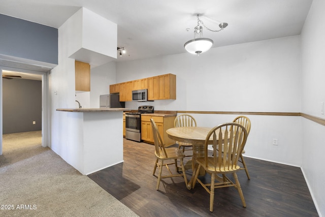 1185 W University Ave Unit 213, Flagstaff, AZ 86001 - kitchen featuring stainless steel appliances, dark wood-style flooring, and a peninsula