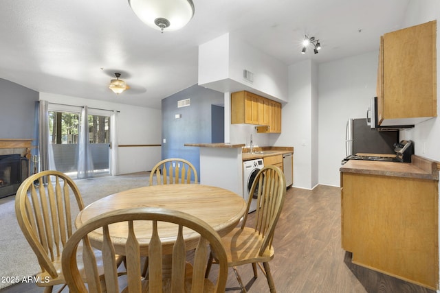 1185 W University Ave Unit 213, Flagstaff, AZ 86001 - dining space featuring washer / clothes dryer, dark wood-style floors, and a tiled fireplace