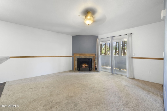 1185 W University Ave Unit 213, Flagstaff, AZ 86001 - unfurnished living room featuring carpet flooring, a tiled fireplace, and ceiling fan