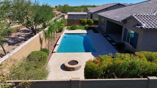 view of pool with an outdoor fire pit and a patio area