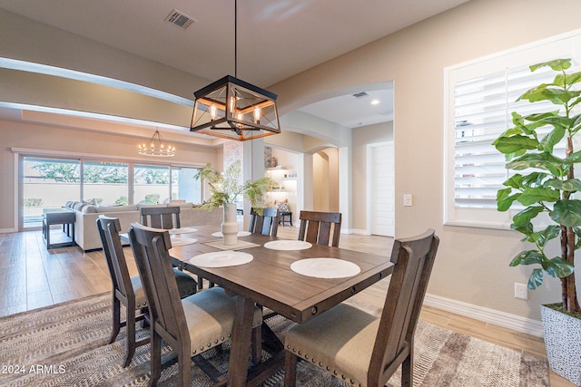 dining space featuring hardwood / wood-style floors and an inviting chandelier