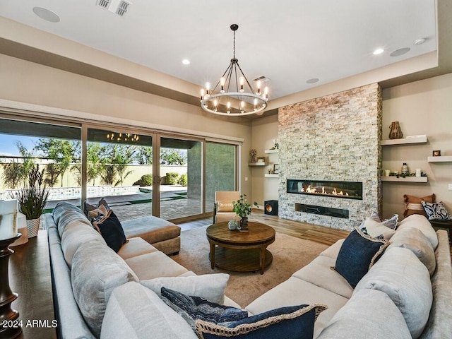 living room with a fireplace, hardwood / wood-style floors, and a notable chandelier