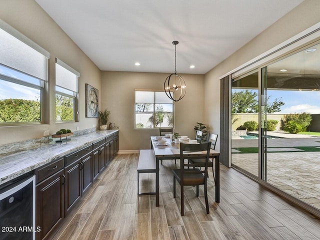 dining area with light hardwood / wood-style floors, a chandelier, and plenty of natural light