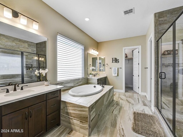 bathroom with vanity and shower with separate bathtub