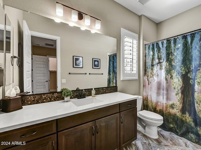 bathroom with vanity, tasteful backsplash, and toilet