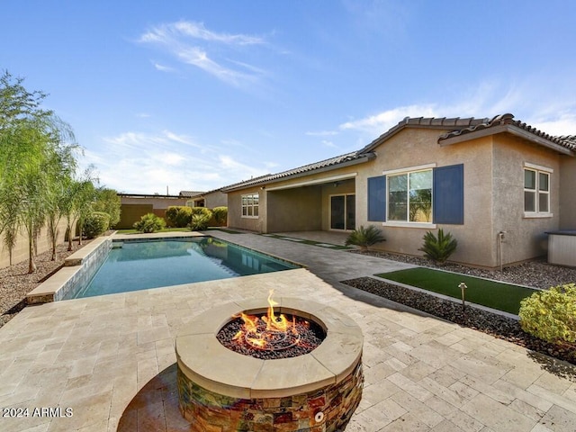 view of pool featuring an outdoor fire pit and a patio