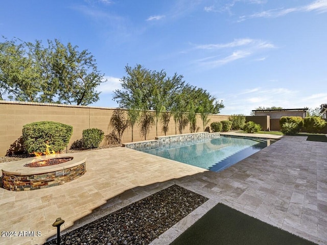 view of swimming pool with an outdoor fire pit and a patio area