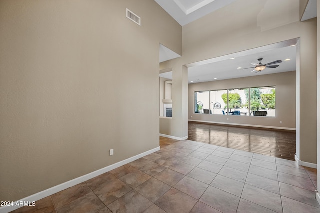 spare room with ceiling fan and light tile patterned floors