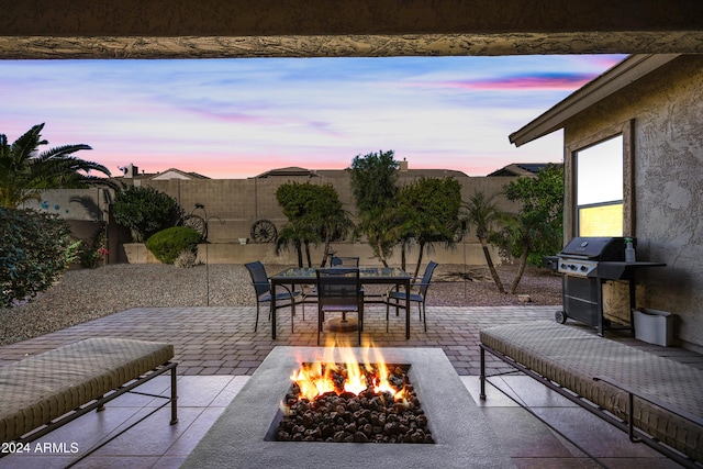 patio terrace at dusk with a grill and a fire pit