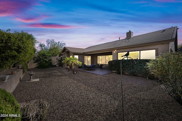 back house at dusk with a patio