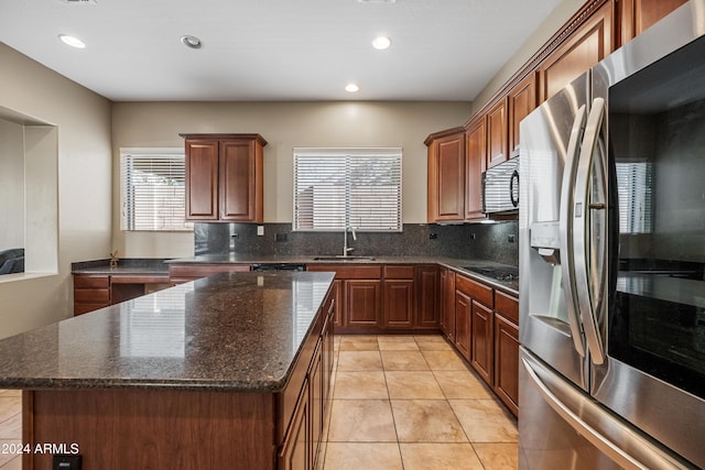 kitchen with light tile patterned flooring, sink, decorative backsplash, stainless steel fridge, and a kitchen island