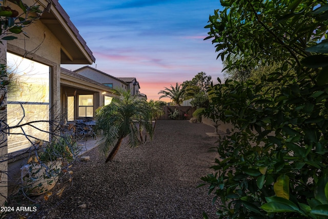 yard at dusk featuring a patio area