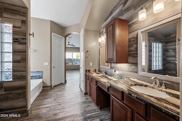 bathroom with a bathing tub, ceiling fan, vanity, and hardwood / wood-style flooring