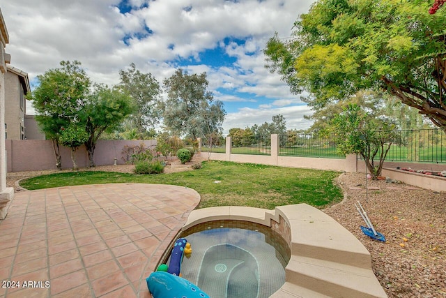 view of patio featuring an in ground hot tub and a fenced backyard