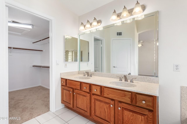 bathroom featuring visible vents, a sink, a spacious closet, and double vanity