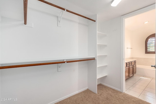 spacious closet featuring light colored carpet and light tile patterned floors