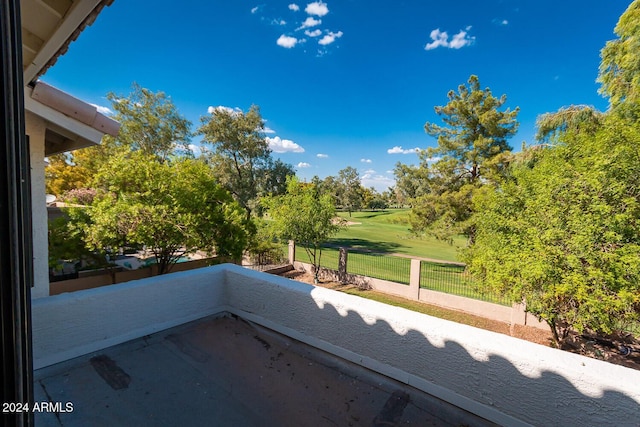 view of patio / terrace featuring a balcony, view of golf course, and fence