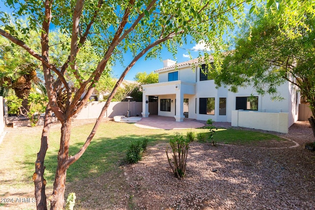 rear view of property featuring a patio, a fenced backyard, a lawn, stucco siding, and a chimney