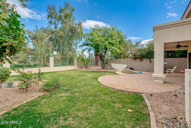 view of yard featuring a fenced backyard, a ceiling fan, and a patio