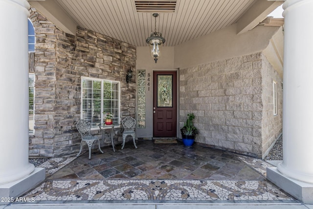 property entrance with a porch and stone siding