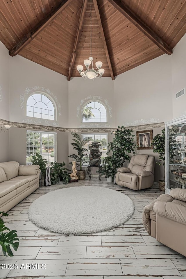 living area with wood ceiling, visible vents, beamed ceiling, an inviting chandelier, and a high ceiling
