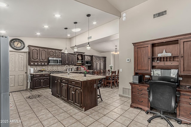 kitchen with light tile patterned floors, visible vents, stainless steel microwave, and lofted ceiling