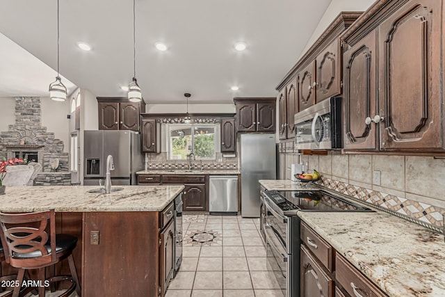 kitchen featuring a sink, appliances with stainless steel finishes, backsplash, and dark brown cabinetry