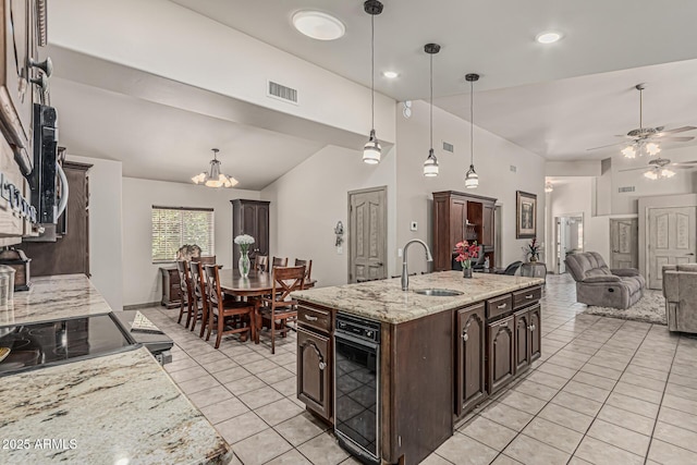 kitchen with visible vents, dark brown cabinets, a sink, light tile patterned floors, and ceiling fan with notable chandelier