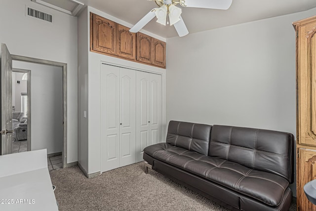 living room featuring light colored carpet, ceiling fan, visible vents, and baseboards