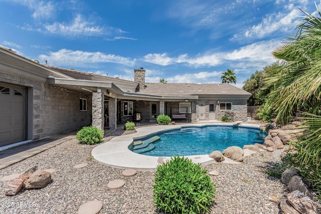 outdoor pool with a diving board and a patio area