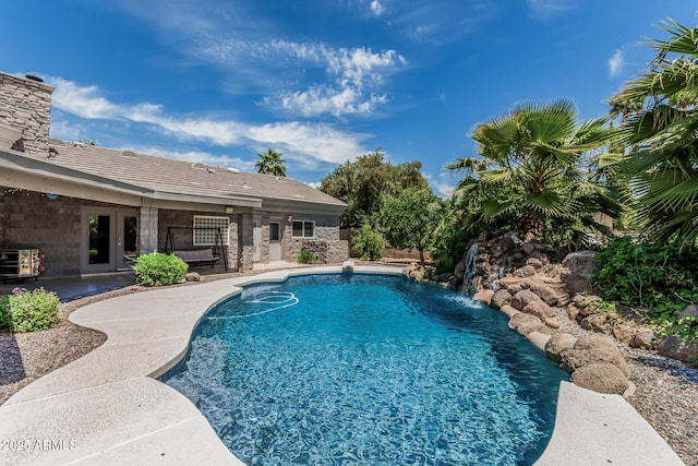outdoor pool with french doors and a patio area