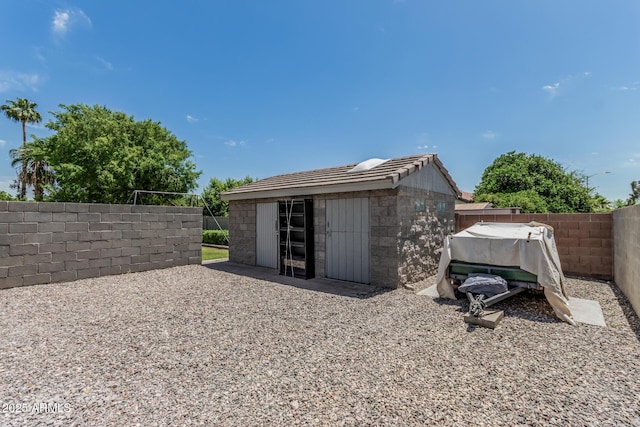 view of outdoor structure featuring fence and an outbuilding
