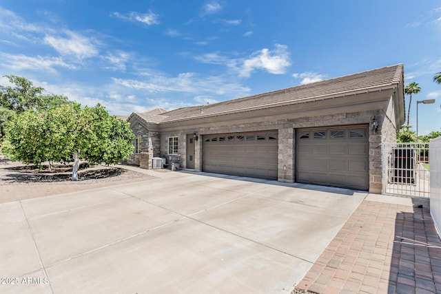 ranch-style house featuring driveway, a tile roof, stone siding, and a garage