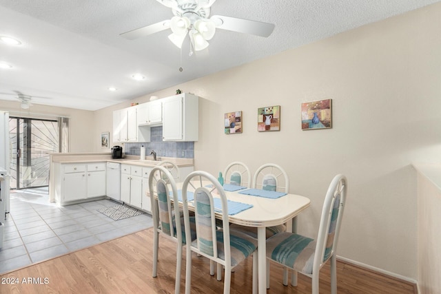 dining space with ceiling fan, a textured ceiling, and light wood-type flooring