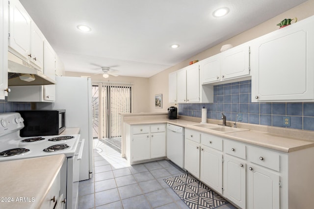 kitchen featuring white appliances, white cabinets, decorative backsplash, light countertops, and a sink