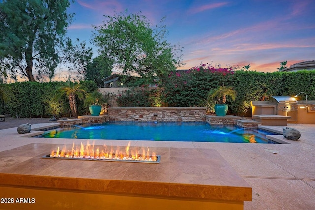 view of swimming pool featuring area for grilling, a fenced backyard, grilling area, a fire pit, and a fenced in pool